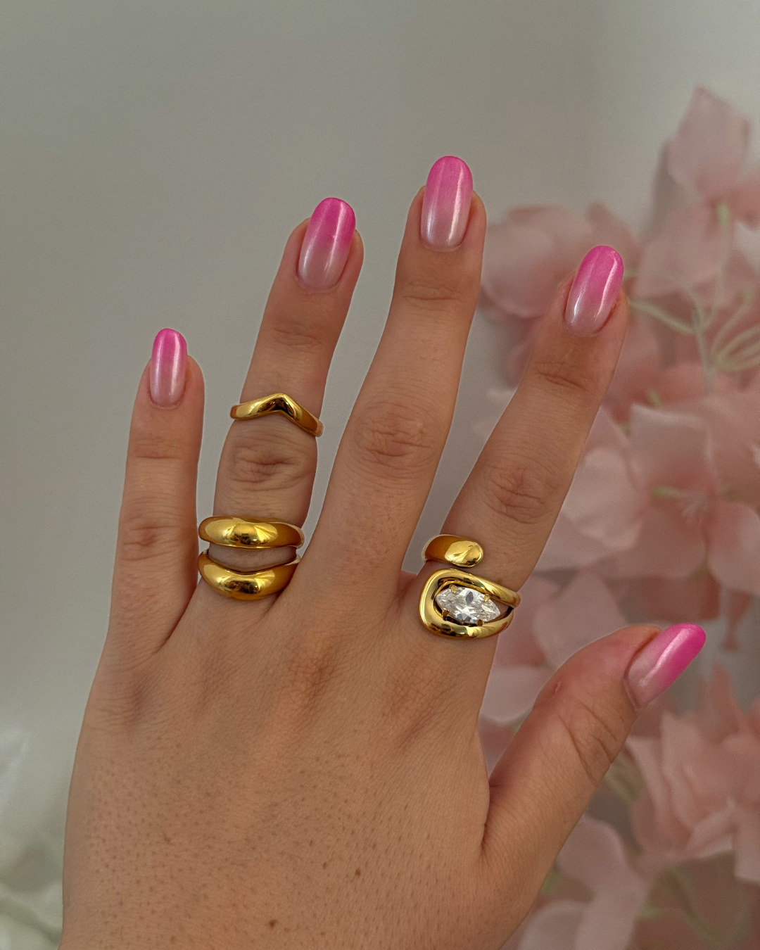 Anello dorato indossato insieme ad altri anelli per look combinato